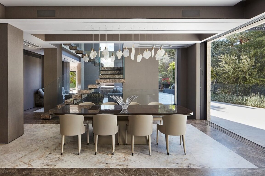 ריצוף פנים טבעי מאבן ושיש בחלל מודרני עם שולחן אוכל יוקרתי ותאורה מעוצבת