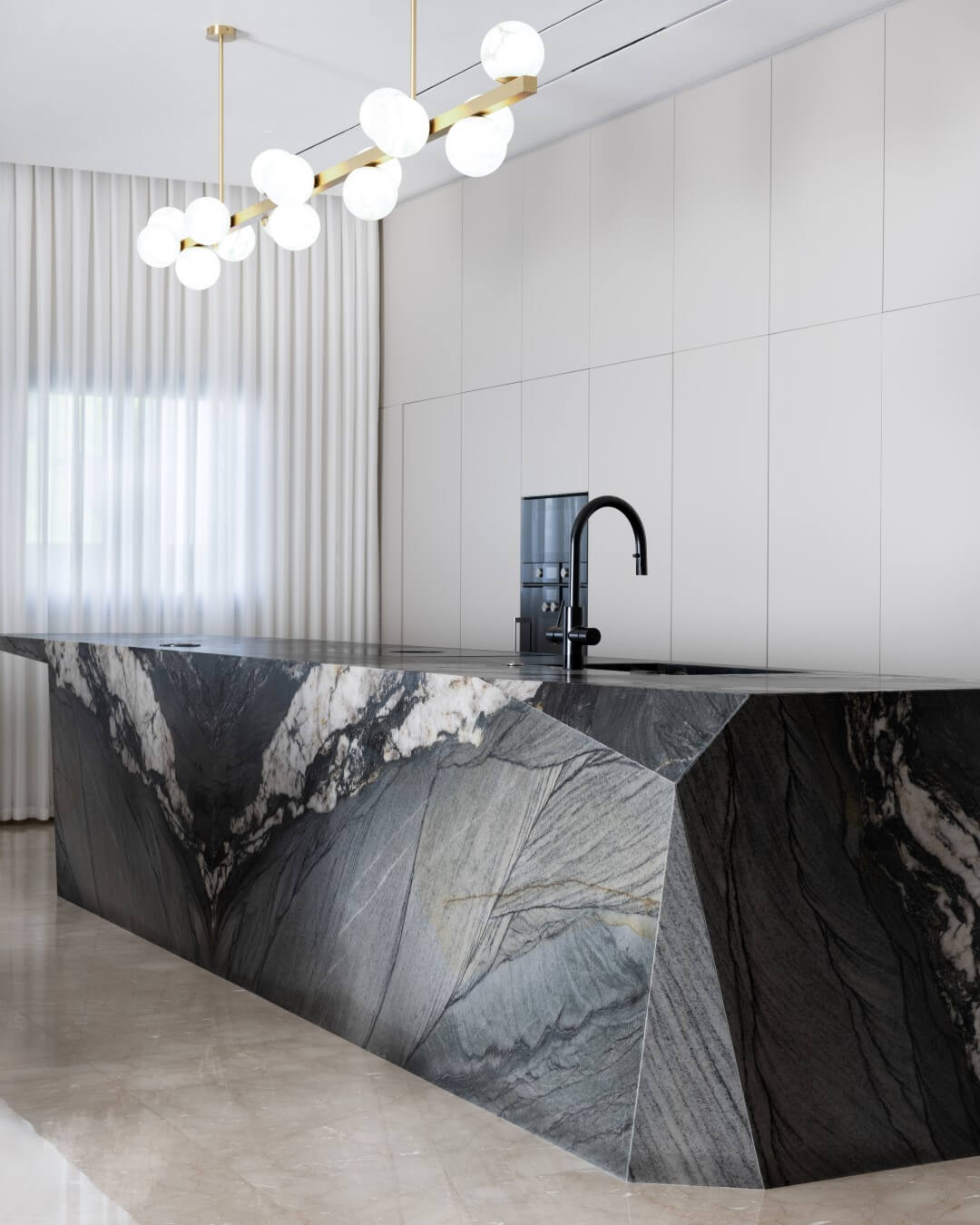 משטח שיש למטבח יוקרתי בעיצוב מודרני עם אי מרכזי מאבן טבעית